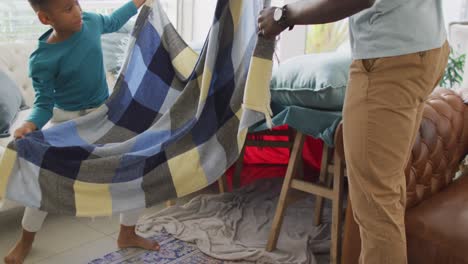 video de la sección media de un padre e hijo afroamericanos preparando la base de sillas y mantas