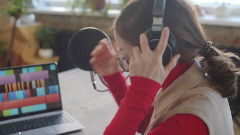 podcaster mujer poniendo auriculares y tomando notas