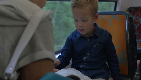 mother and child exploring map in train
