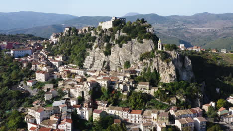 Aerial-reveal-shot-of-Bagnoli-del-Trigno-town-with-San-Silvestro-church-between-two-rock-spurs,-Isernia-and-Molise-region,-Italy,-4K