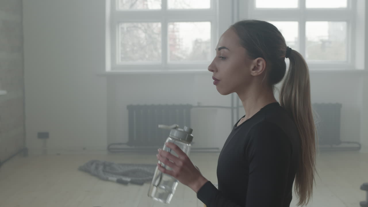 Female Athlete Drinking Water After Workout