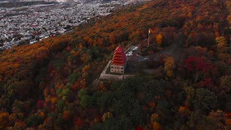 The-pagoda-overlooking-Reading-city-during-colorful-fall-season,-PA,-USA-aerial-dolly-in