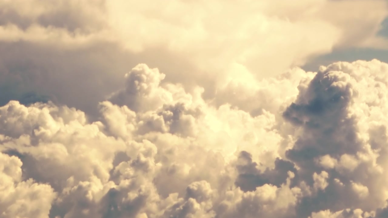 Pan Across Dynamic High Contrast Cumulus Clouds with Deep Dark Shadows with Blue Sky in Background. Aerial View.