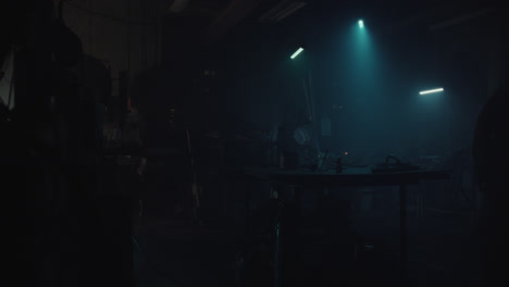 a bombmaker assembles a bomb in his workshop at night