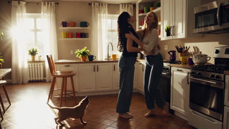 two women and a dog sharing a warm moment in a bright kitchen