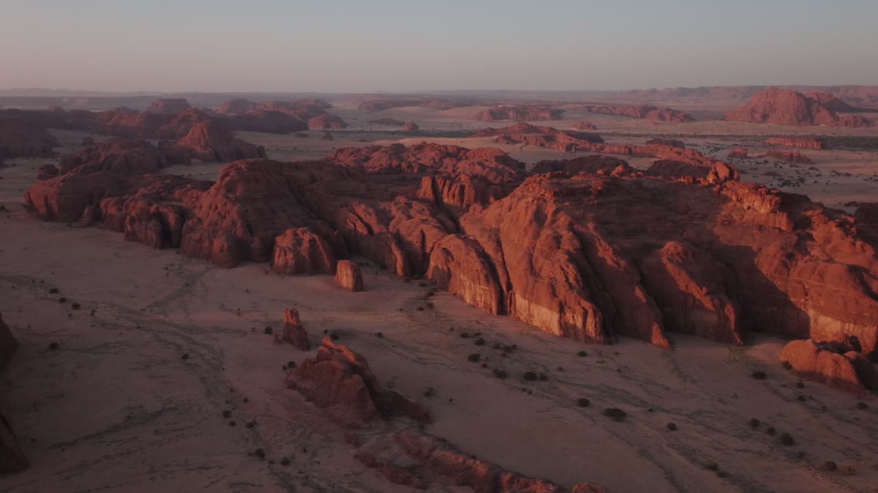 Luftdroneudsigt over en bjergkæde i sandklitterne i Sahara-ørkenen ved den gyldne time