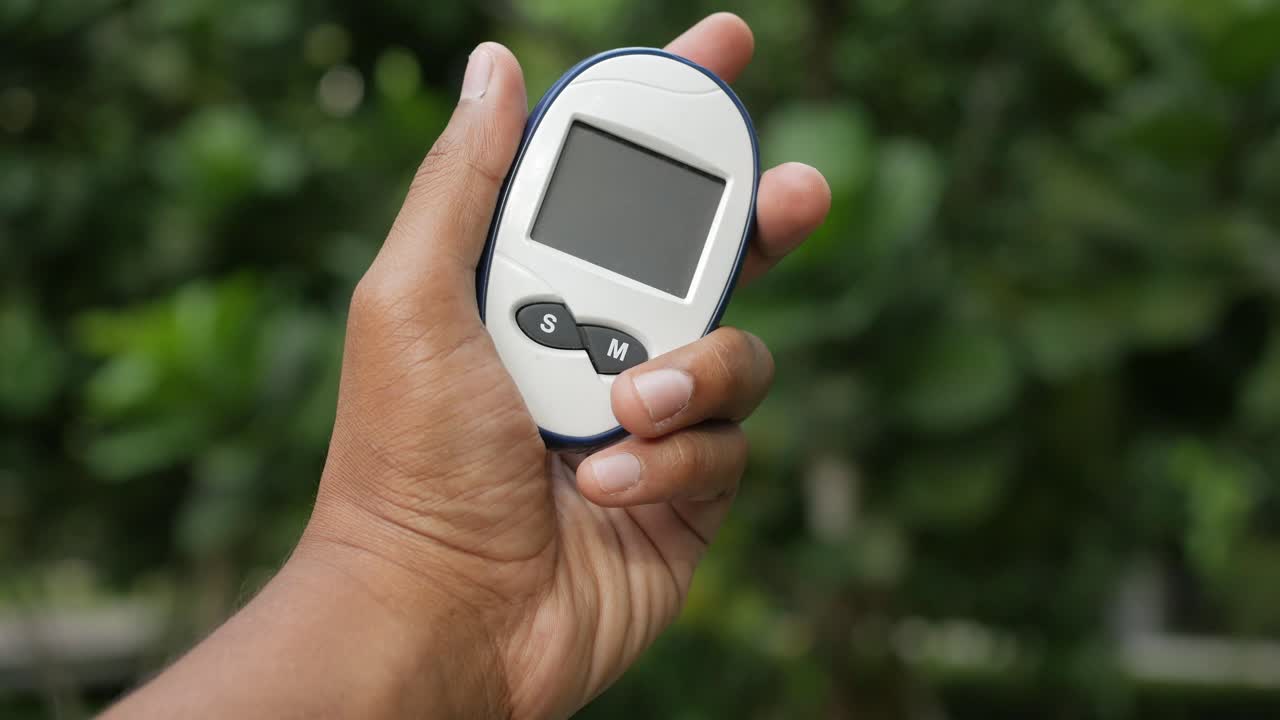 포도당 측정기를 들고 있는 남자