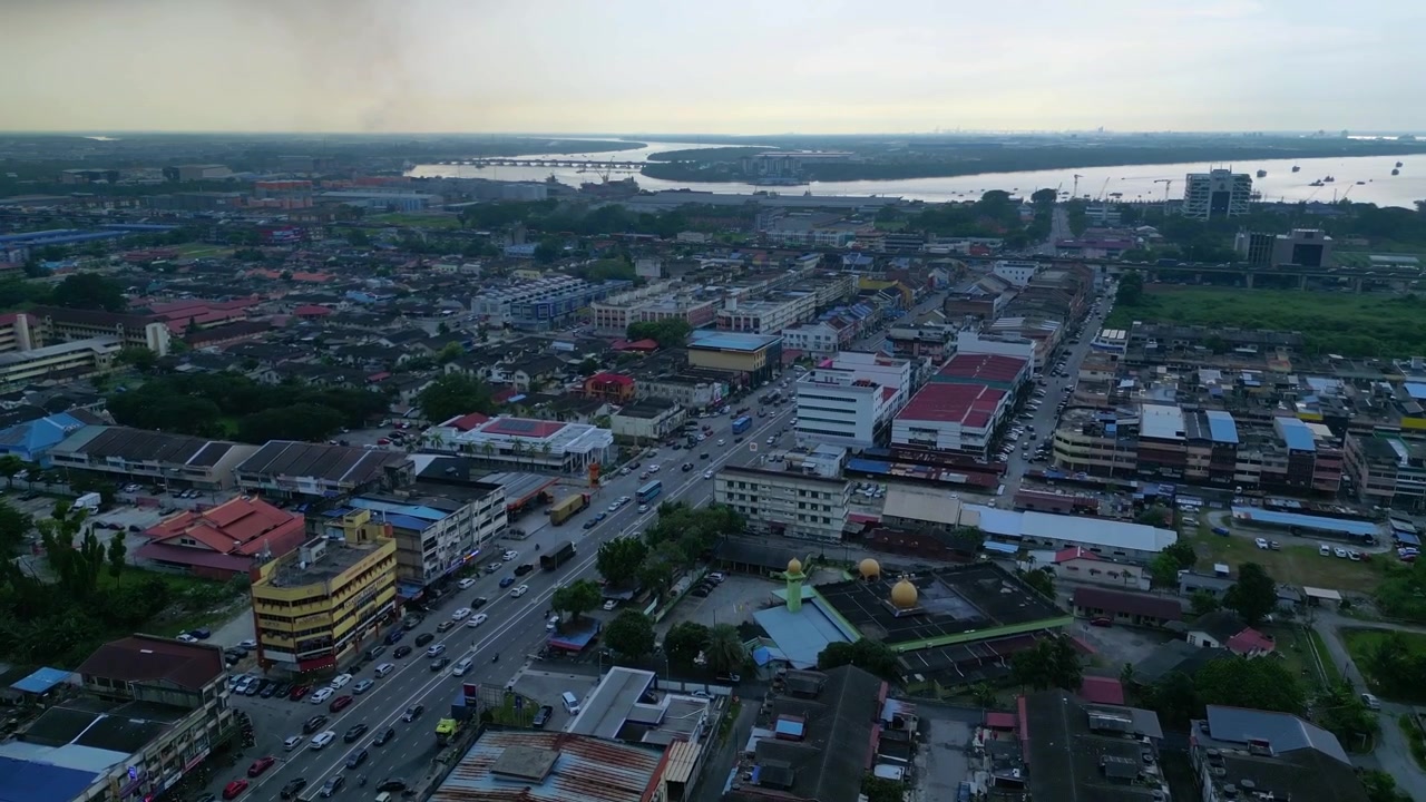 Vista elevata del paesaggio urbano di Port Klang con edifici, una strada principale trafficata e un corso d'acqua con navi. Migliore vista aerea, volo in avanti, panorama da drone.