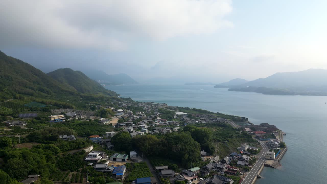 Stunning drone shot over lush green island in Seto inland sea with road to distance