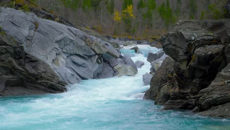 Wide-view-of-a-beautiful-waterfall-with-clear-blue-glacier-water