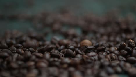 close-up time-lapse granos de café cayendo, derramándose sobre la mesa verde oscuro