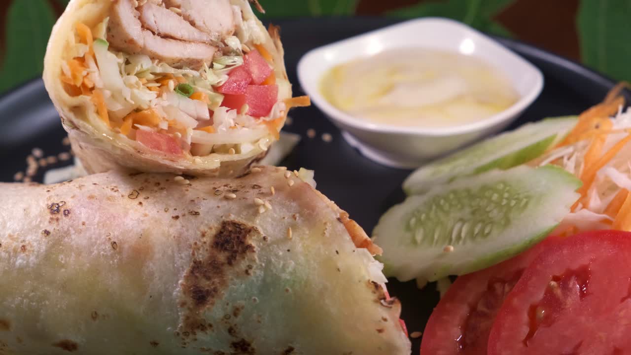 deliciosas envolturas de kebab de pollo con relleno girando en un plato con cierre