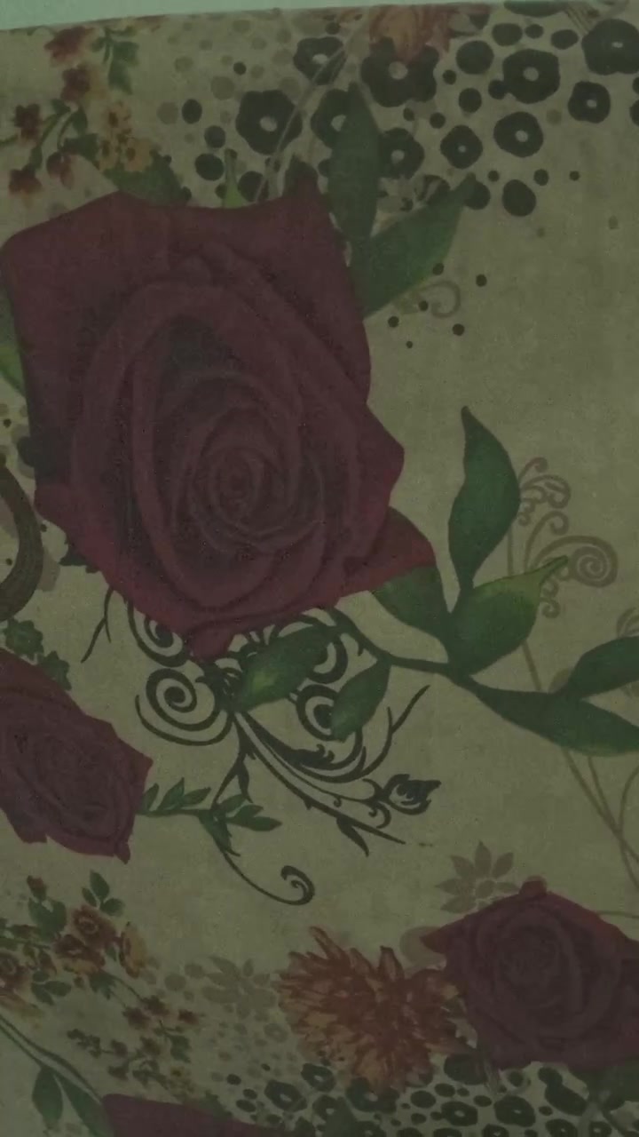 Primo piano di tessuto a fantasia floreale con rose e paisley
