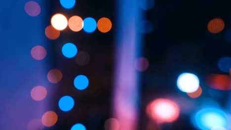 guirnalda de navidad con luces de colores junto a la ventana contra el fondo de la ciudad y el movimiento de los coches, primer plano. luces de navidad borrosas. bokeh.