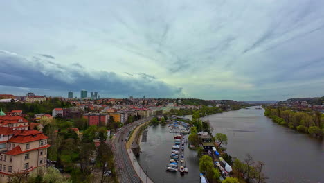 Panoramic-view-of-Prague-with-red-rooftop-houses,-river,-dock-and-greenery