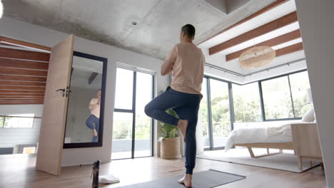 Senior-biracial-man-practicing-yoga-meditation-at-home