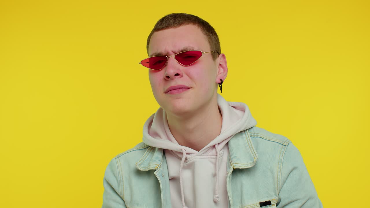 선글라스를 입은 남자가 심각한 표정으로 포즈를 취하고 있습니다.