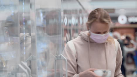 Woman-in-mask-buying-yogurt-in-supermarket