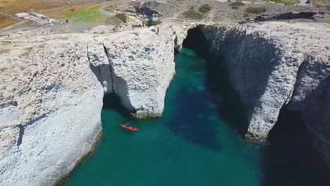 Playa-Escondida-De-Papafragas-Con-Aguas-Turquesas-Cristalinas-Y-Formaciones-Rocosas-De-Túneles-En-La-Isla-De-Milos,-Grecia