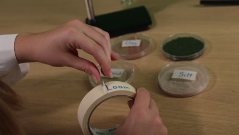 hands labeling soil samples with tape and marker