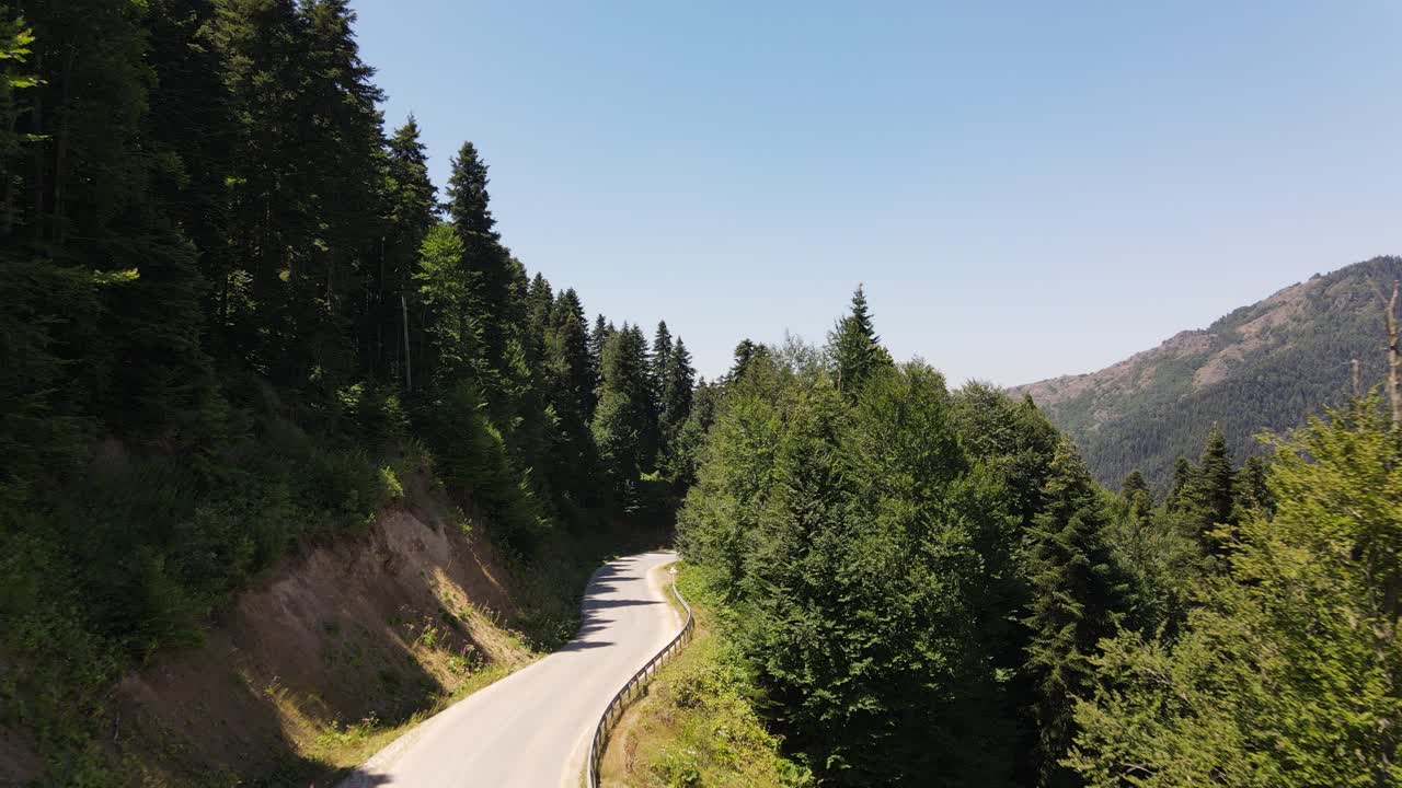 자연 사이의 도로를 천천히 달리는 자동차