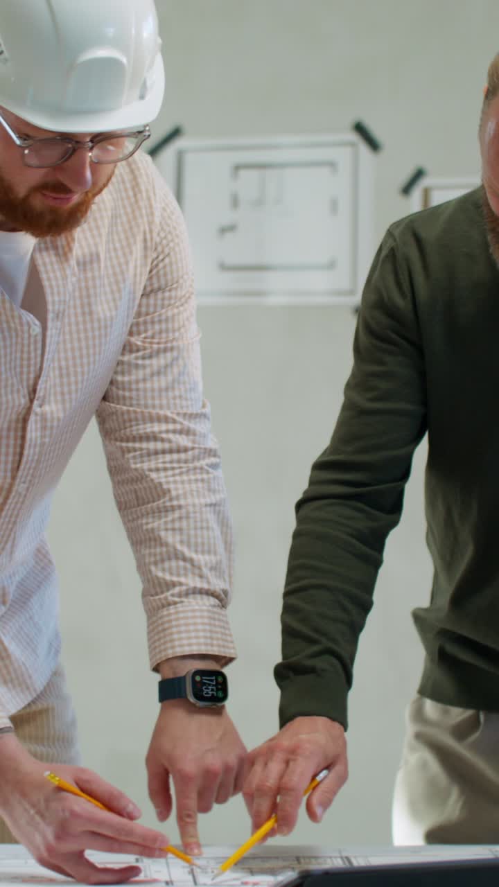 Two architects examining blueprint