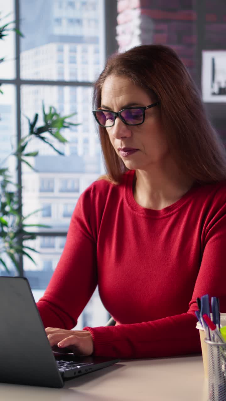 Vertical Video Mature person overseeing business schedule and planning activities at desk