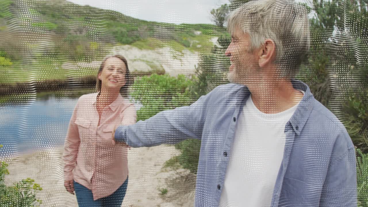 Muž natahuje ruku dozadu a vede ženu, která ho chytá za ruku a kráčí vpřed podél laguny pro cestovní reklamu.