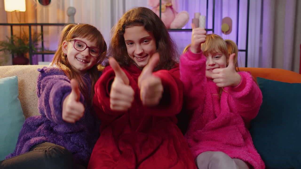 Happy siblings children girls showing thumbs up like sign positive something good positive feedback