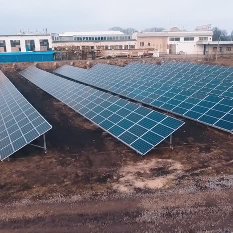 modern sunny collectors on the field. solar panels generate clean sunny energy. photovoltaic cells on the background of industrial buildings.