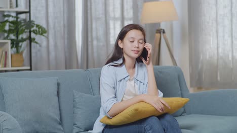 teenager talking on phone on couch