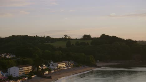 Sunrise-View-Over-Saundersfoot-Village-Beach-Coastline-with-Blue-Sky-and-Orange-Clouds-in-Wales-UK-4K