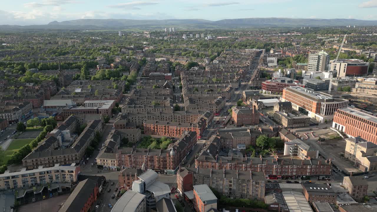 Aerial orbit around Byres Road in Glasgow's West End flats and Glasgow University in sunny evening, Scotland, UK