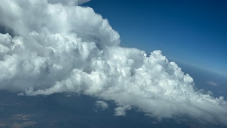 piloto inmersivo pov volando en un cielo azul con una enorme tormenta de nubes por delante, como visto por los pilotos en un giro a la izquierda