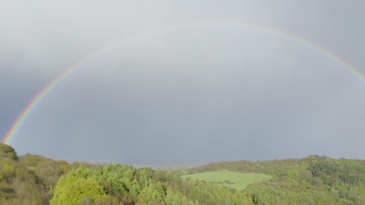 우스터셔에 있는 클렌트 언덕의 푸른 언덕 풍경 위에 완전히 형성된 무지개
