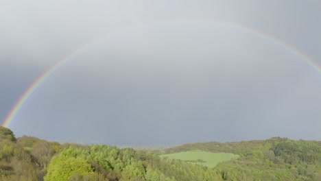 un arco iris completamente formado sobre el paisaje de verdes colinas de clent hills en worcestershire