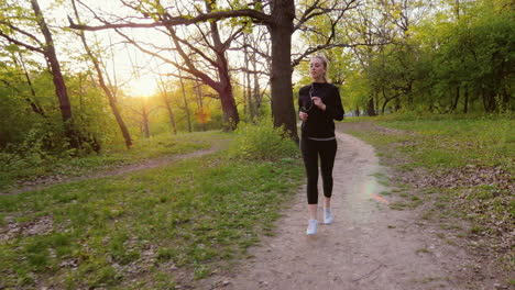 jogging in spring forest woman running in the forest the sun is shining it in the back