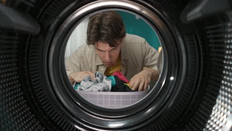 man searching for matching socks in a washing machine