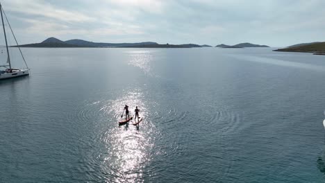 people on sup boards at sea - aerial view of stand up paddle - kornati