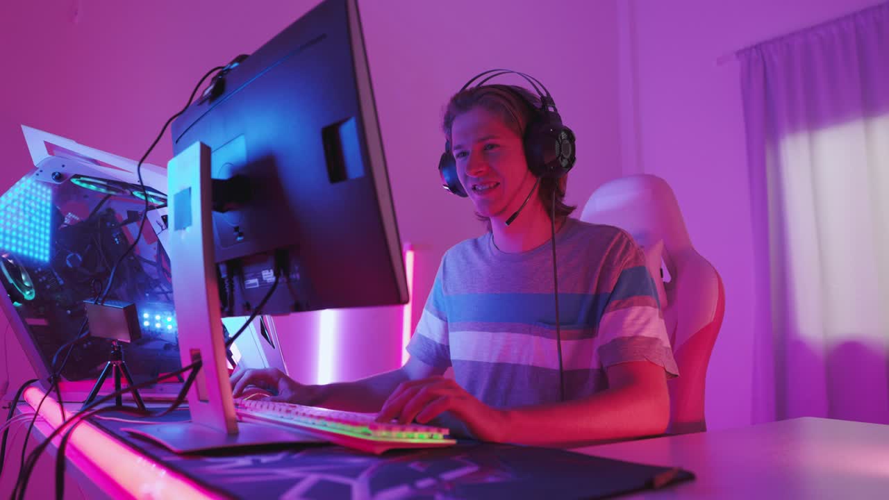 emocionado jugador jugando videojuego en línea con una maqueta de pantalla verde en su potente computadora personal. habitación y pc tienen coloridas luces de neón. noche acogedora en casa.