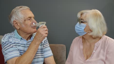 elderly couple using inhaler at home