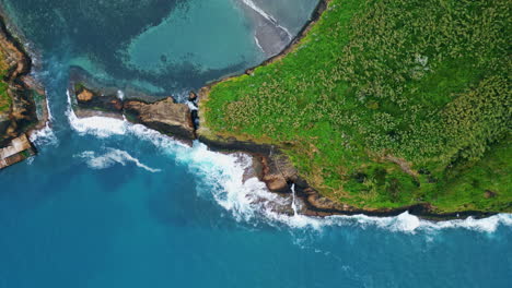 turquoise waves foaming cape shoreline aerial top view. green hill blue lagoon