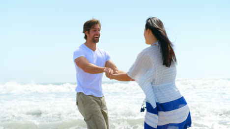 cámara lenta de una feliz joven pareja caucásica en la playa 4k