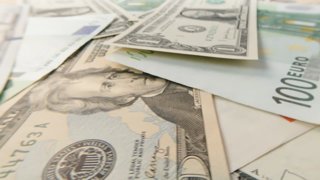 Rotating banknotes of dollars and euros of various denominations close-up. Background of rotating dollars and euros. 4k macro raw video.