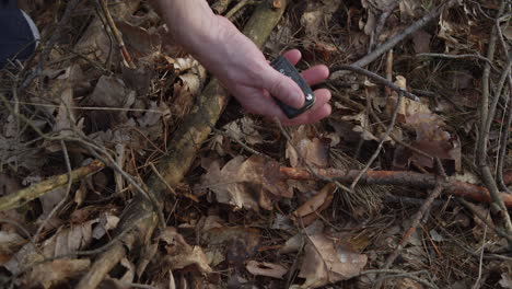 Car-keys-lost-in-forest-finally-found,-hands-close-up-high-angle-view,-lucky-day-or-crime-evidence-concept