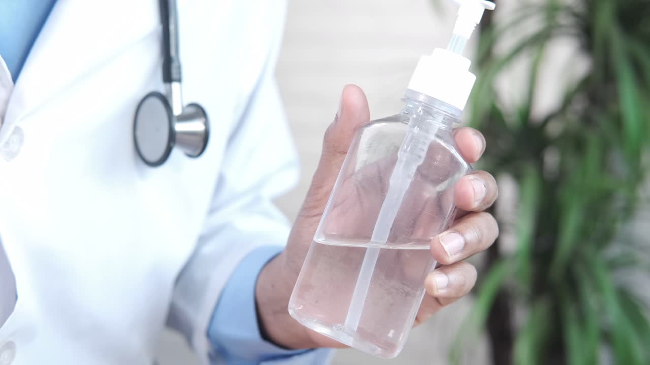 médico con desinfectante para las manos