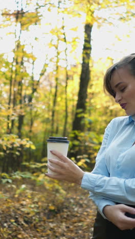 woman drinking hot tea. woman warm up with hot tea in autumn park