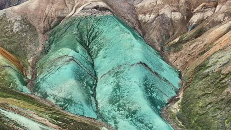 aerial drone orbit movement, close-up shot of the middle section of grænihryggur, the green rock in landmannalaugar, iceland, emphasizing the medium tones of orange and green