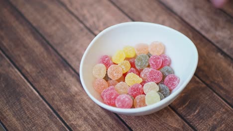 child's hand picking up gummy candy from bowl