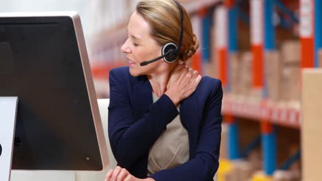 stressed female warehouse manager working on computer